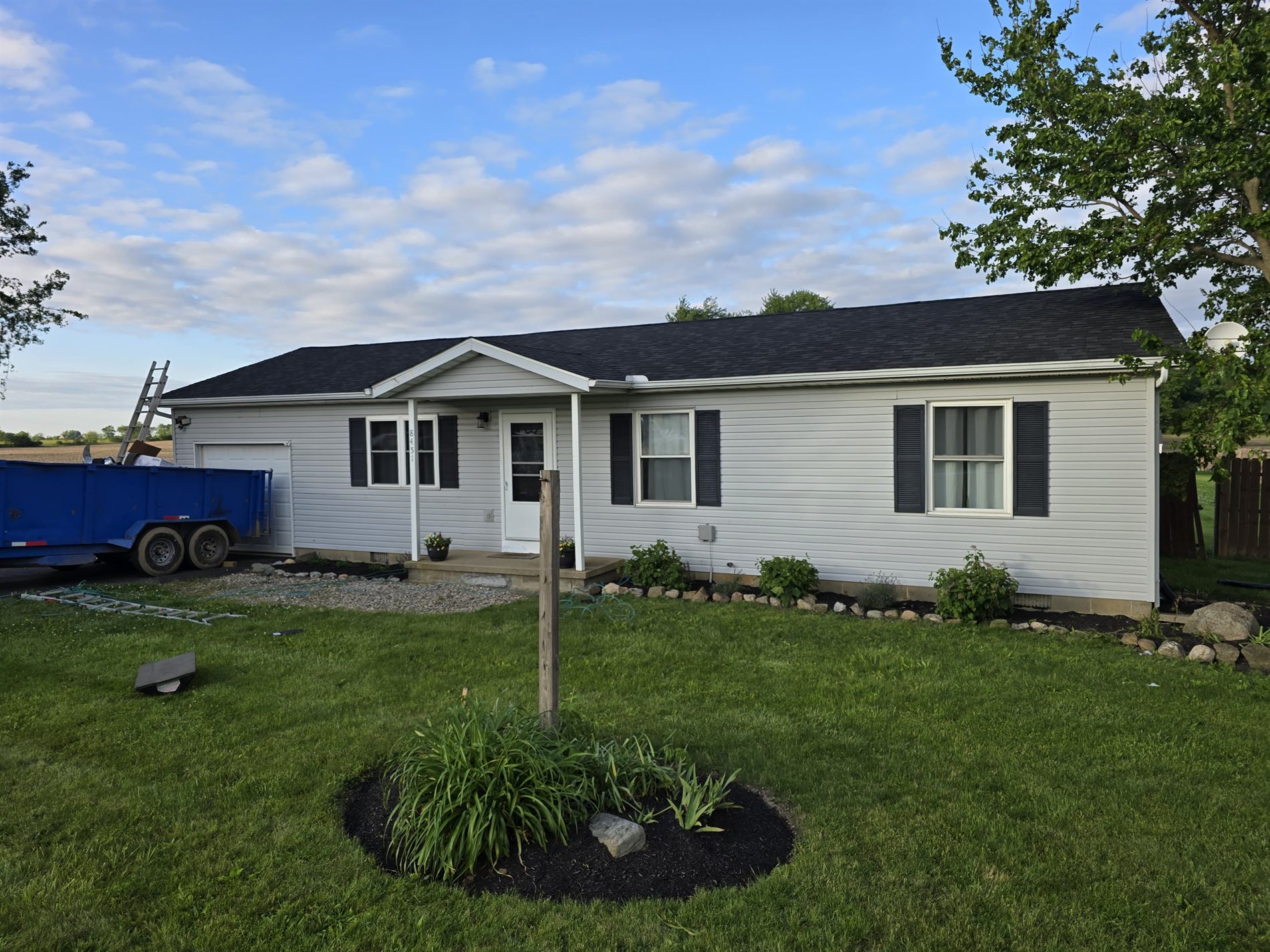 Finished siding and dark roof under blue sky